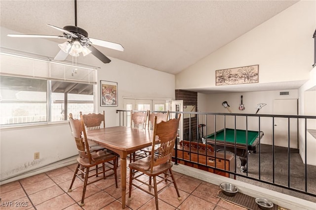 tiled dining area with a textured ceiling, ceiling fan, vaulted ceiling, and visible vents
