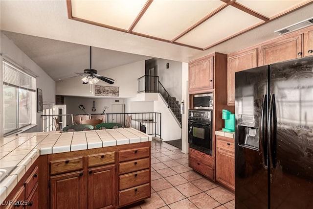 kitchen featuring ceiling fan, tile counters, light tile patterned floors, visible vents, and black appliances