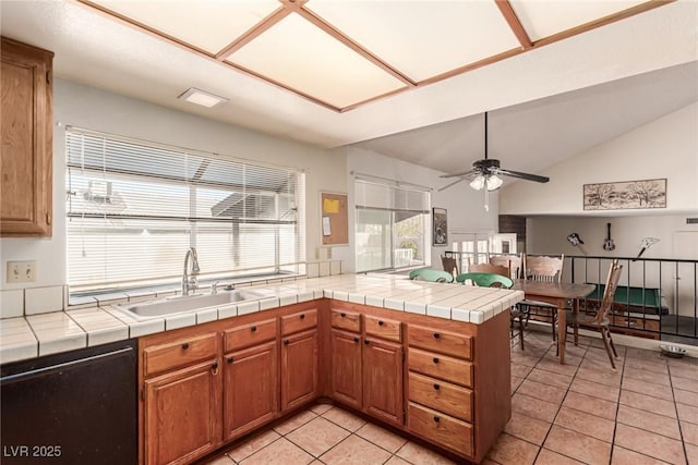 kitchen with ceiling fan, a sink, a peninsula, light tile patterned floors, and dishwashing machine