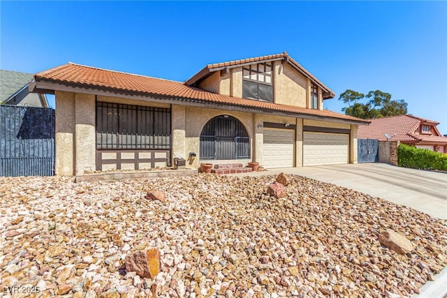 view of front facade featuring a tiled roof, a garage, fence, concrete driveway, and stucco siding