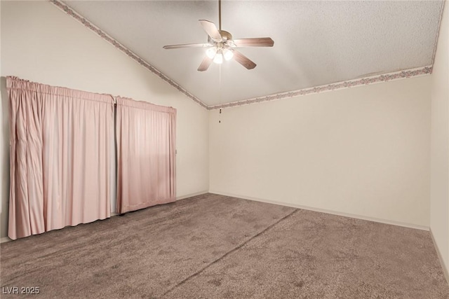 carpeted spare room featuring ceiling fan and vaulted ceiling