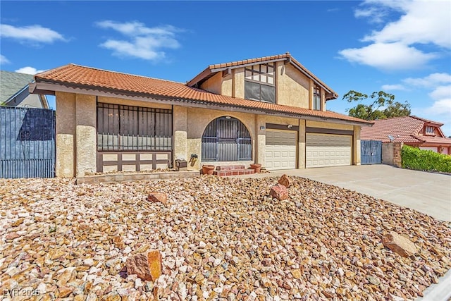 view of front of property with fence, a tile roof, a garage, stucco siding, and driveway