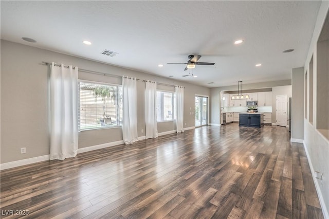 260 Pioneers Peak, Henderson, NV 89002 - unfurnished living room with dark wood-style floors, visible vents, baseboards, and ceiling fan