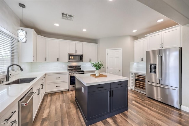 260 Pioneers Peak, Henderson, NV 89002 - kitchen featuring a sink, wood finished floors, appliances with stainless steel finishes, and white cabinets