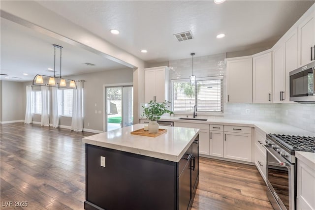 260 Pioneers Peak, Henderson, NV 89002 - kitchen featuring tasteful backsplash, visible vents, appliances with stainless steel finishes, wood finished floors, and a sink