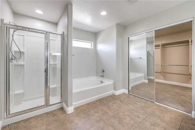 260 Pioneers Peak, Henderson, NV 89002 - bathroom with a walk in closet, a shower stall, tile patterned flooring, baseboards, and a bath