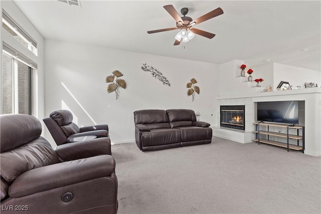 carpeted living area featuring baseboards, a fireplace, and ceiling fan