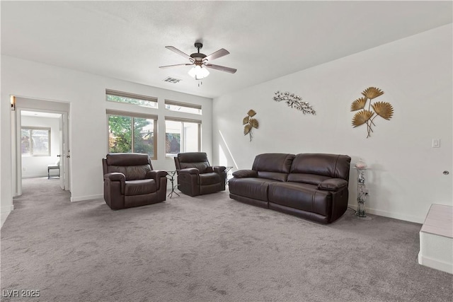 carpeted living area with baseboards, ceiling fan, visible vents, and plenty of natural light