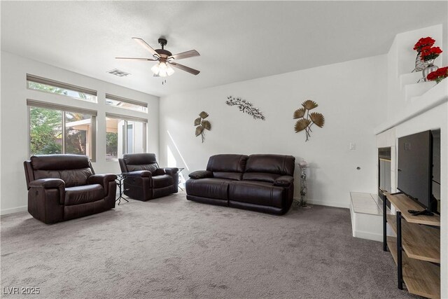 carpeted living area featuring a ceiling fan, baseboards, and visible vents