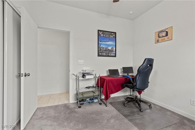 carpeted office with baseboards and ceiling fan