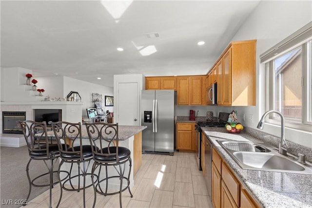 kitchen with a kitchen bar, recessed lighting, stainless steel appliances, a sink, and visible vents