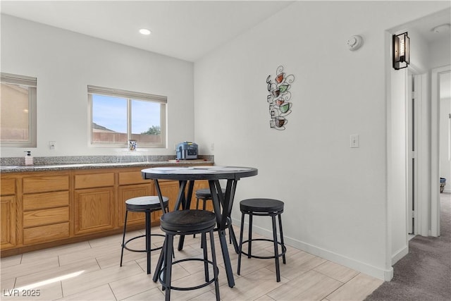 kitchen with baseboards, brown cabinetry, recessed lighting, and wood finish floors