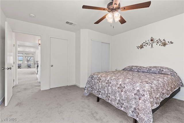 carpeted bedroom with baseboards, a closet, ceiling fan, and visible vents
