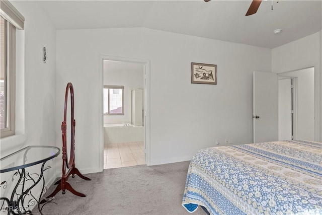 bedroom featuring carpet, baseboards, connected bathroom, a ceiling fan, and lofted ceiling