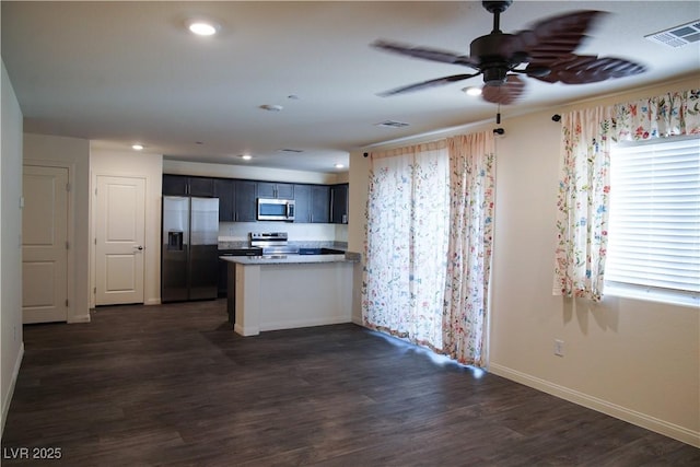 2765 Frosted Teal Ave, North Las Vegas, NV 89086 - kitchen with appliances with stainless steel finishes, a ceiling fan, a peninsula, baseboards, and dark wood finished floors