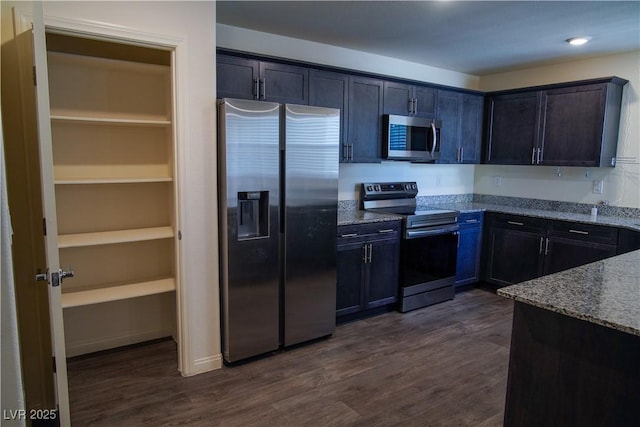 2765 Frosted Teal Ave, North Las Vegas, NV 89086 - kitchen with stainless steel appliances, stone countertops, and dark wood-style flooring
