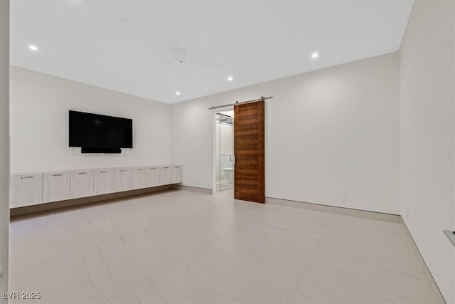 unfurnished living room featuring a barn door and recessed lighting