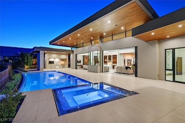 pool featuring area for grilling, a patio area, and an in ground hot tub