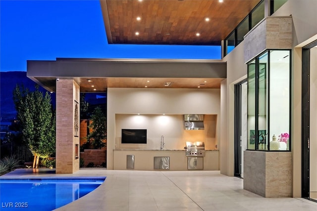 exterior space featuring exterior kitchen, area for grilling, a sink, and a patio