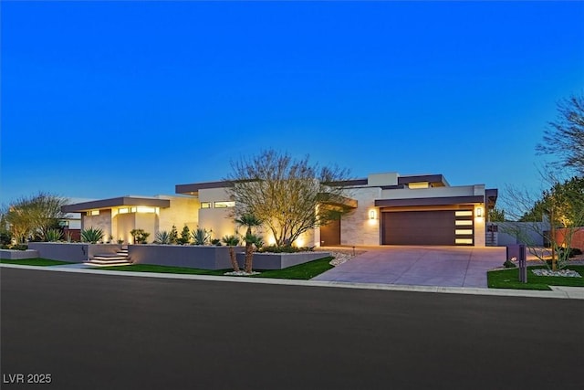 modern home featuring stucco siding, an attached garage, and concrete driveway