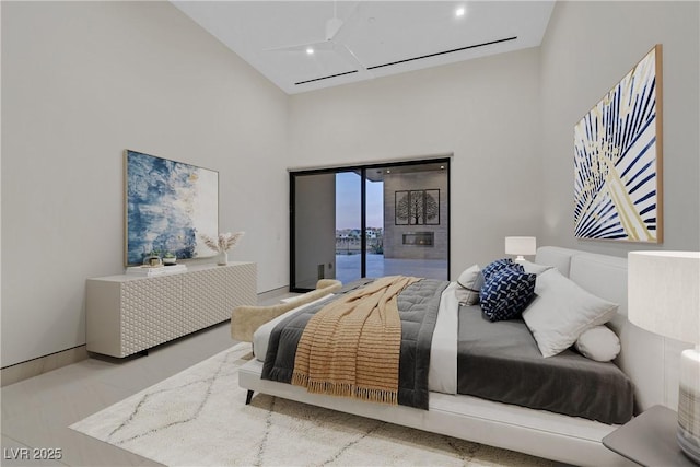 bedroom with high vaulted ceiling and access to outside
