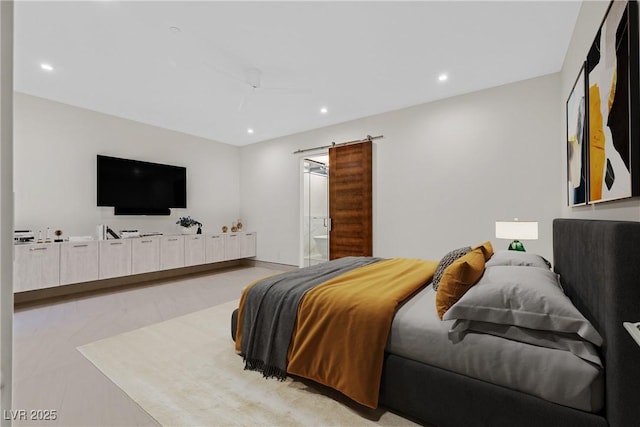bedroom featuring a barn door, ensuite bath, a ceiling fan, and recessed lighting