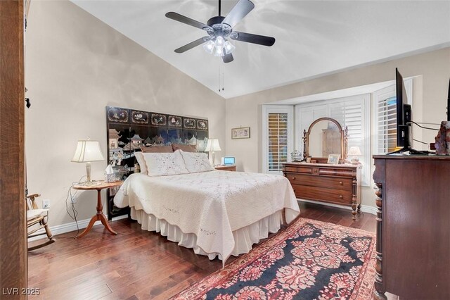 bedroom with dark wood finished floors, ceiling fan, baseboards, and lofted ceiling