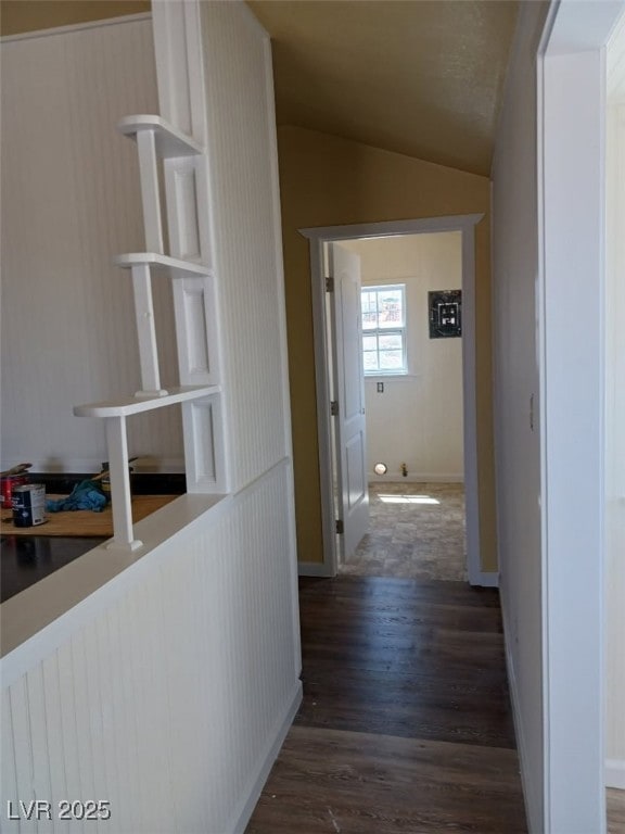 hall featuring baseboards, lofted ceiling, and wood finished floors