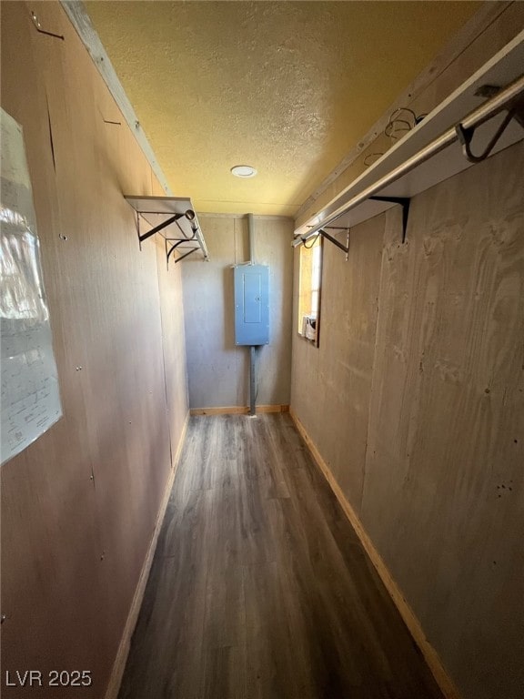 interior space with baseboards, a textured ceiling, and wood finished floors