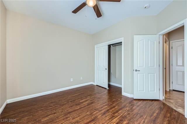unfurnished bedroom with dark wood-type flooring, a ceiling fan, baseboards, and a closet