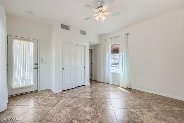 interior space featuring baseboards, visible vents, and ceiling fan