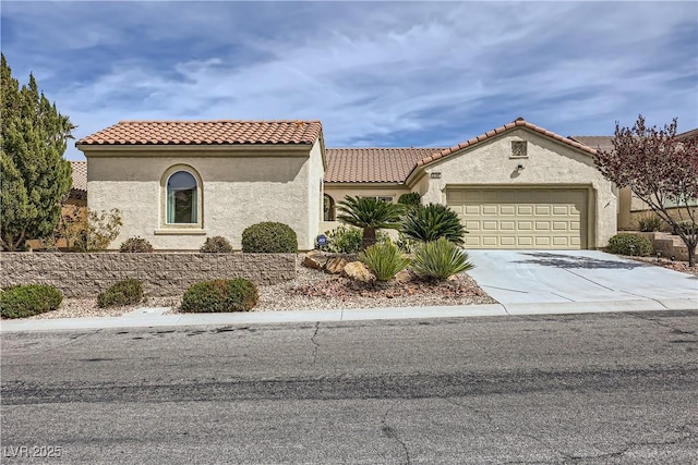 mediterranean / spanish-style house featuring a tile roof, concrete driveway, a garage, and stucco siding