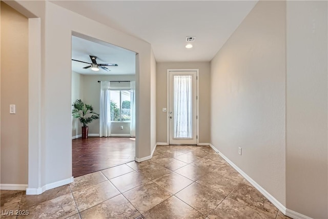 foyer featuring a ceiling fan, tile patterned floors, baseboards, and visible vents