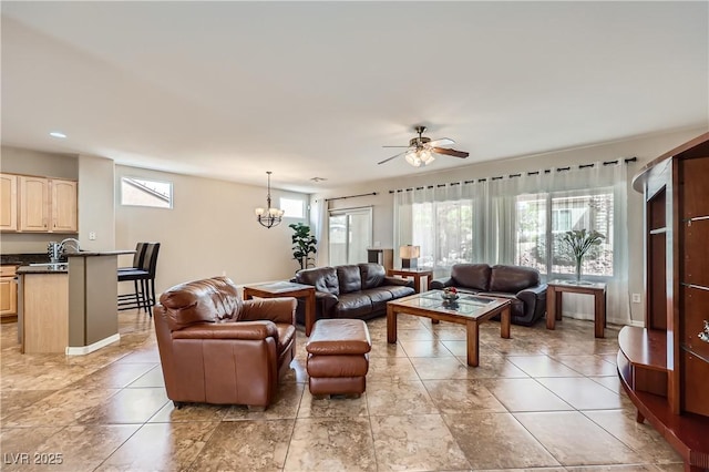 living room with light tile patterned floors, ceiling fan with notable chandelier, baseboards, and a wealth of natural light