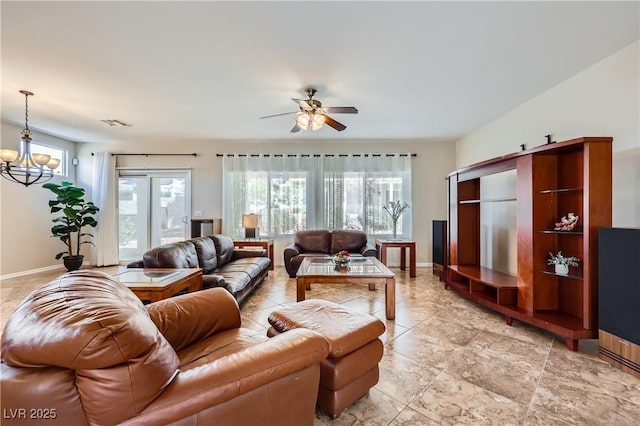 living area with ceiling fan with notable chandelier, visible vents, and baseboards