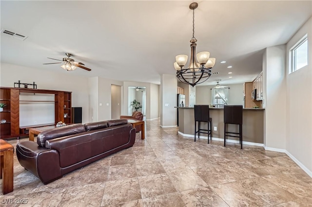 living room with recessed lighting, visible vents, ceiling fan with notable chandelier, and baseboards