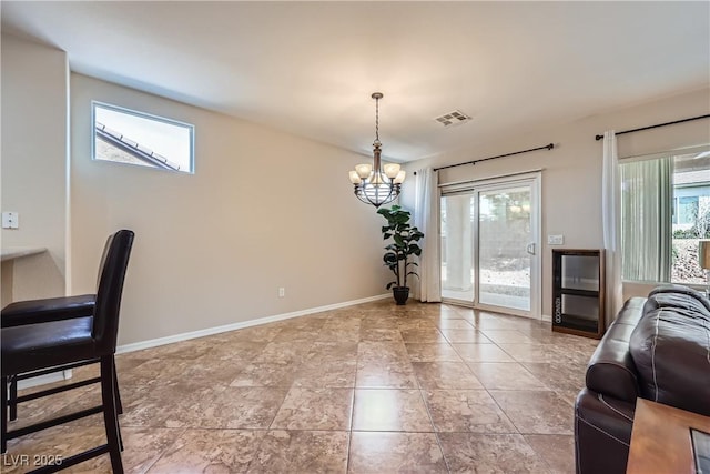 dining space featuring a notable chandelier, visible vents, and baseboards