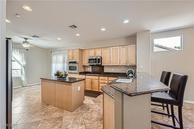 kitchen featuring a sink, stainless steel appliances, visible vents, and light brown cabinets