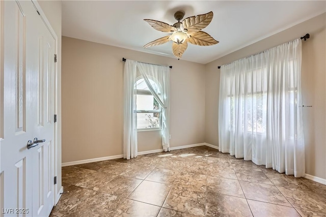 unfurnished room featuring baseboards and ceiling fan