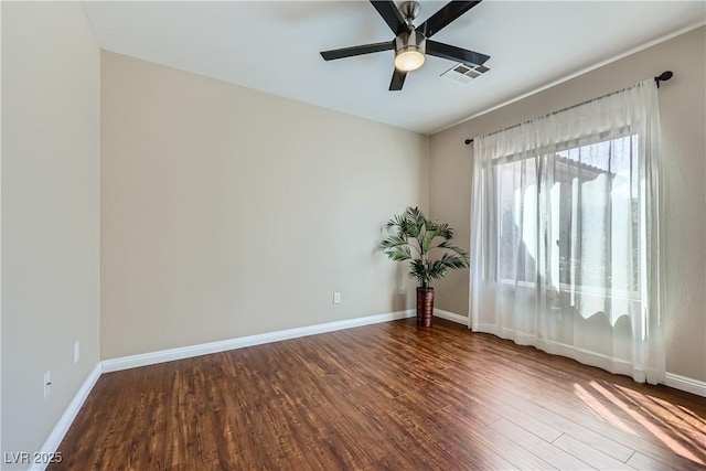 unfurnished room featuring visible vents, baseboards, wood finished floors, and a ceiling fan