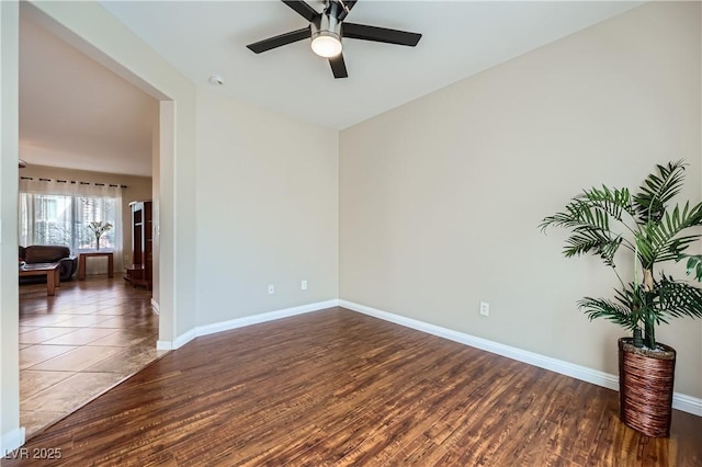 unfurnished room featuring baseboards, wood finished floors, and a ceiling fan