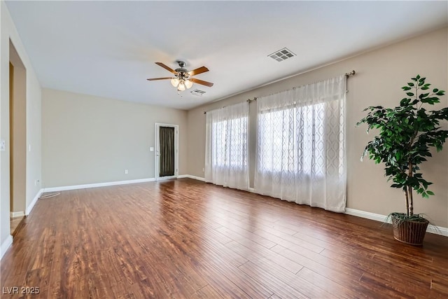 spare room with visible vents, baseboards, wood finished floors, and a ceiling fan