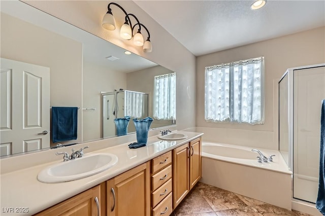 bathroom with double vanity, a stall shower, a garden tub, and a sink