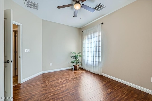 spare room featuring a ceiling fan, wood finished floors, visible vents, and baseboards
