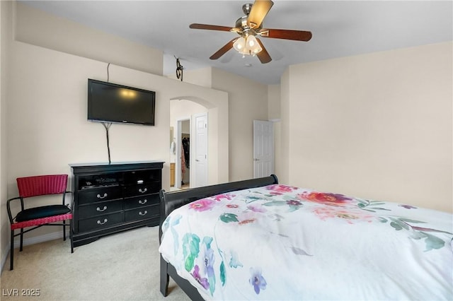 bedroom with carpet floors, a ceiling fan, and arched walkways