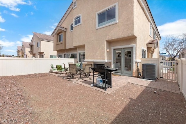 rear view of house featuring a patio, central AC, a fenced backyard, and stucco siding