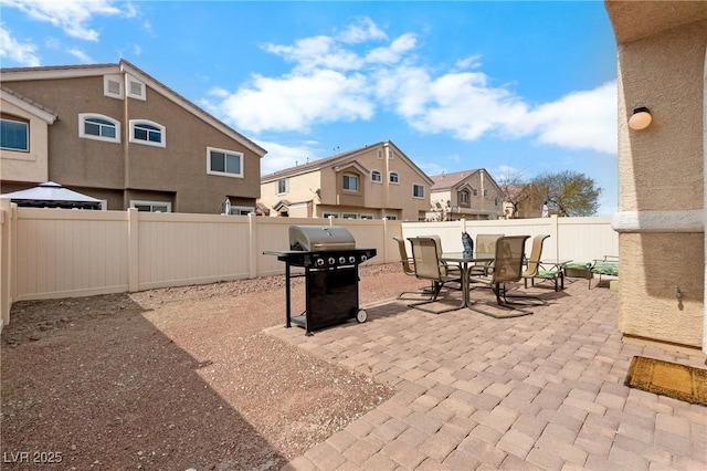 view of patio with a residential view, outdoor dining area, grilling area, and a fenced backyard