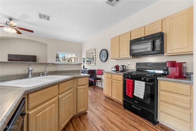 kitchen featuring a sink, visible vents, light brown cabinets, and black appliances