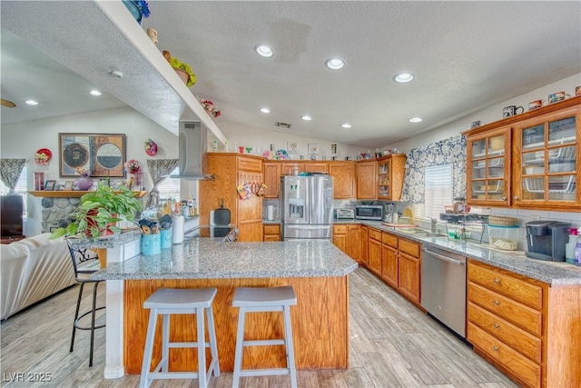 3424 Mount Charleston Dr, Pahrump, NV 89048 - kitchen with appliances with stainless steel finishes, island exhaust hood, vaulted ceiling, a peninsula, and a breakfast bar area