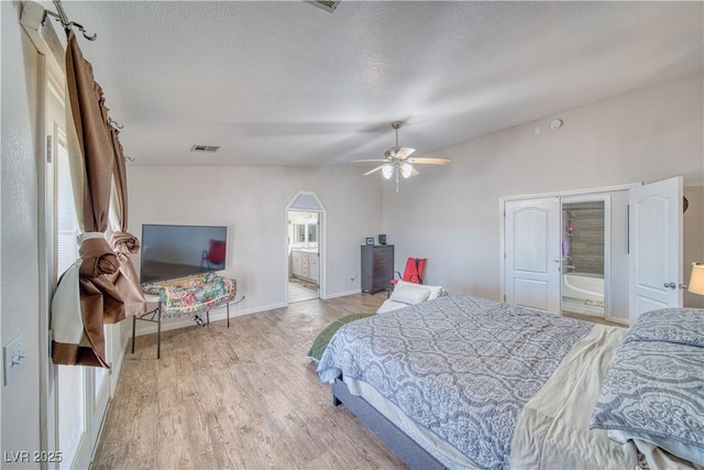 3424 Mount Charleston Dr, Pahrump, NV 89048 - bedroom with ensuite bathroom, light wood-style flooring, baseboards, a textured ceiling, and lofted ceiling